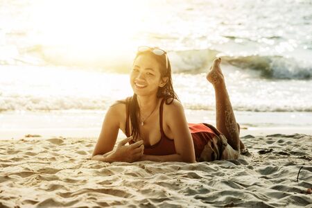 portrait of asia beautiful woman lying on the beachの写真素材