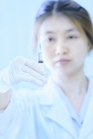 asia young doctor woman with syringe in hospitalの写真素材