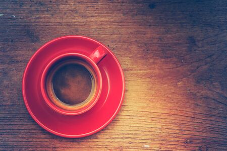 red cup of hot coffee on wood tableの写真素材