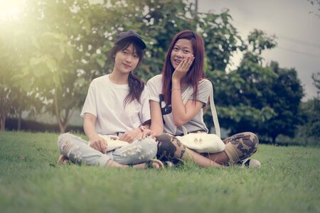 portrait of two asia young girl with bag on park, on outdoorの写真素材