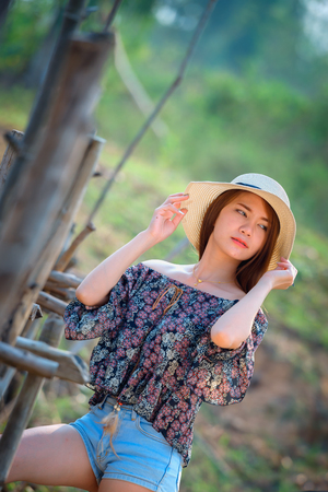 asia woman in Off  Shoulder shirt and short jeans with hat standing on natureの写真素材