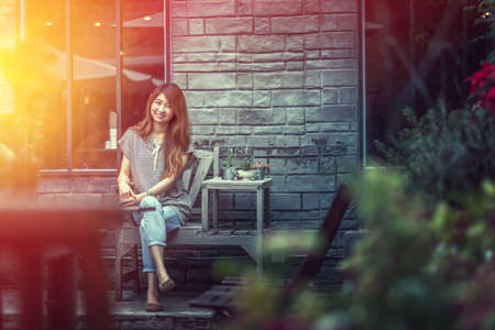 asia beautiful woman siting on chair and relax outside of her home
