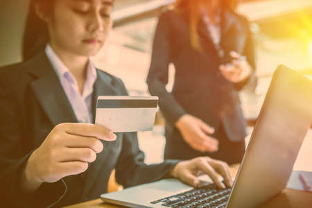 Young business woman holding credit card and using laptop computer. Online shopping conceptの写真素材