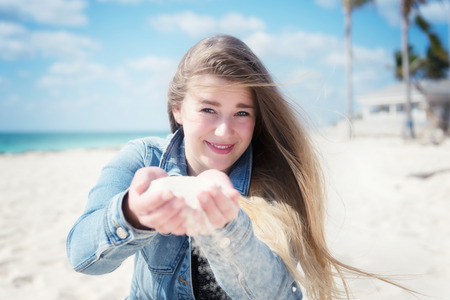 portrait of young beautiful woman in Relaxation On Tropical Beach of with sand in hand