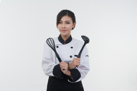 portrait of asia clef woman with ladle posing on white backgroundの写真素材