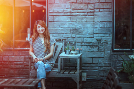 asia beautiful woman siting on chair and relax outside of her homeの写真素材