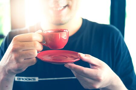 Man holding red cup of coffee, close up