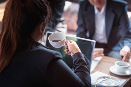young business woman drinking hot coffee during meeting in officeの写真素材