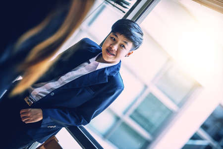 portrait of asia young businessman on window in officeの写真素材