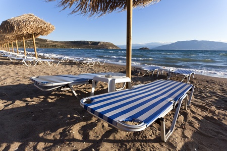 Empty sandy beach with a row of chairsの写真素材