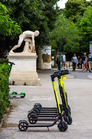 Electric scooters parked in sidewalk in downtown Athens, Greeceのeditorial素材