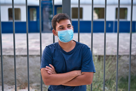 Young teen boy wearing face mask outdoor due to the Coronavirus Pandemic