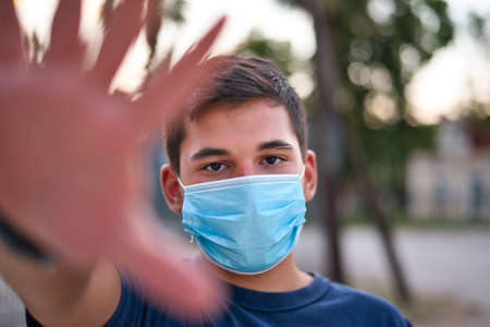 Young teen boy wearing face mask outdoor due to the Coronavirus Pandemicの写真素材