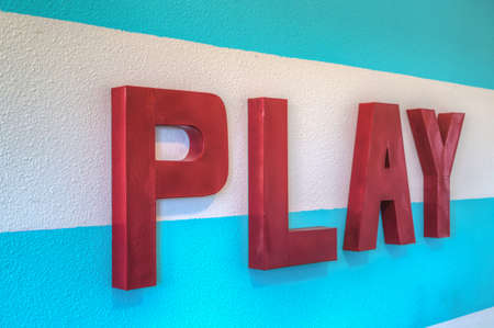 Giant PLAY sign with blue striped background