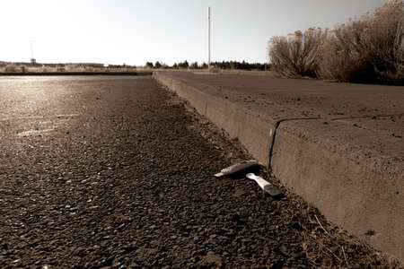 Pregnancy test tossed on rural highway sepia tonedの写真素材