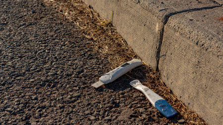 Discarded pregnancy test strip by the side of the road