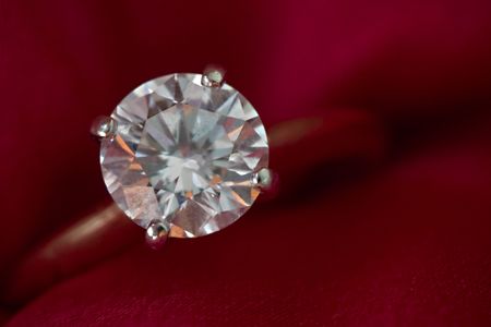 Close up of a diamond ring on red silkの写真素材