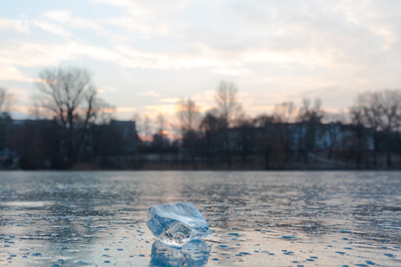 An icecube on a frozen lake in Berlin during sunriseの写真素材