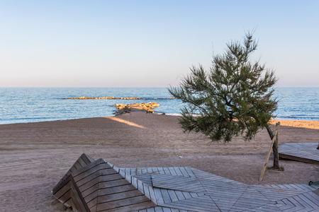 Mediterranean sea at vinaros spain including small rocky pier and an abstract wooden dockの写真素材