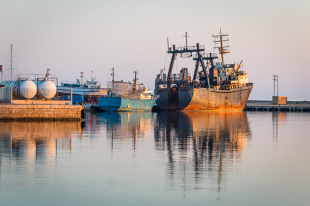 Rusty old boats during sunset in a mediterranean city in spainの写真素材