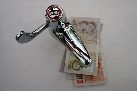 A tap and English pound notesの写真素材