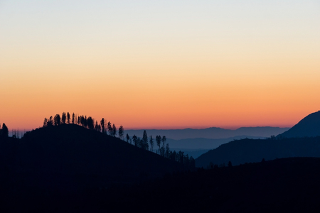 Mountain and Tree Silhouettes at Sunset in Yosemite National Park, Californiaの写真素材
