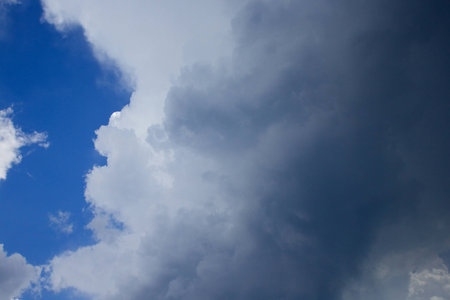 Stormy and fluffy clouds on the background of bright blue sky.の写真素材