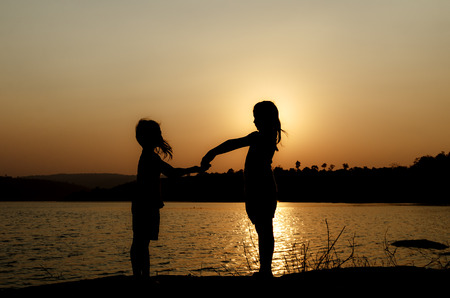 silhouette brotherhood on the lakesideの写真素材