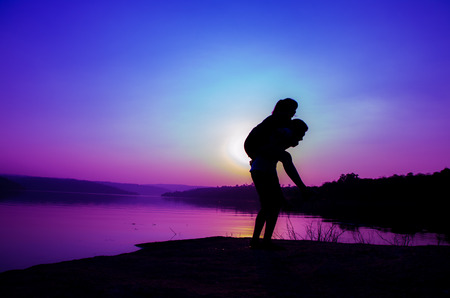 silhouette couple at the lake sideの写真素材