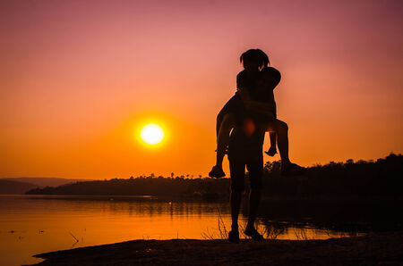 silhouette couple at the lake sideの写真素材