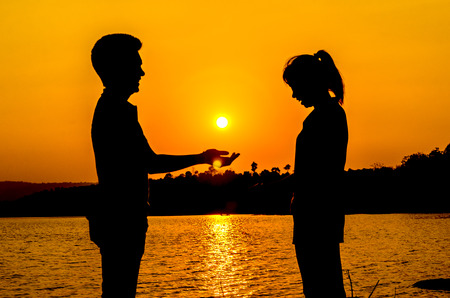 silhouette couple on the lakesideの写真素材