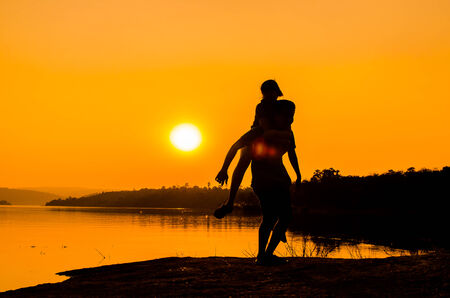 silhouette couple on the lakesideの写真素材