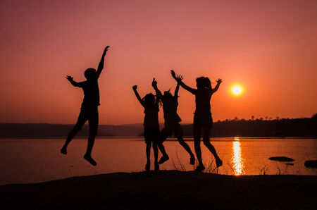 silhouette family jumping, sunset holidayの写真素材