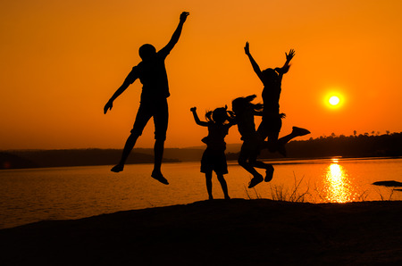 silhouette family jumping, sunset holidayの写真素材