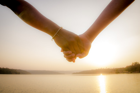 Couple hand in hand nearly the lakeの写真素材
