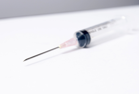 Close-up of medical syringe on white の写真素材