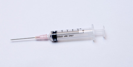Close-up of medical syringe on white の写真素材