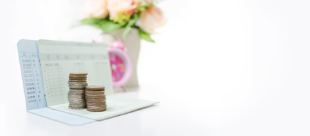 Stack of coins on saving bank accound book on the white background with copy space, Selective focus on coins shallow depth of fieldの写真素材