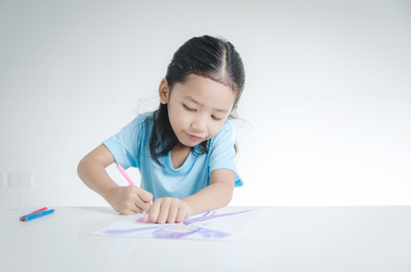 Portrait of smile Asian little girl drawing with color pencilの写真素材
