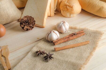 Anise cinnamon and garlic on hemp sackcloth for Bakery Ingredients over wooden tableの写真素材
