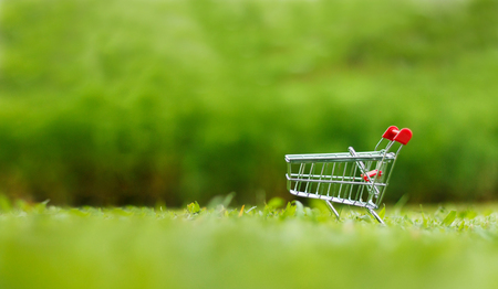 Close up shot of shopping cart over nature green background shallow depth of field with copy spaceの写真素材