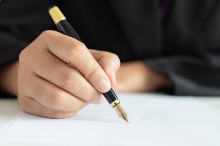 Close up shot hand of business woman using the pen to write on the white paper select focus shallow...