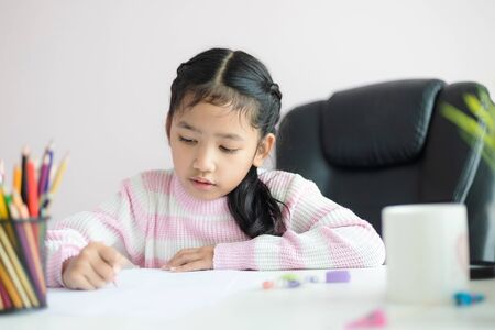 Little Asian girl doing homework for education concept select focus shallow depth of field
