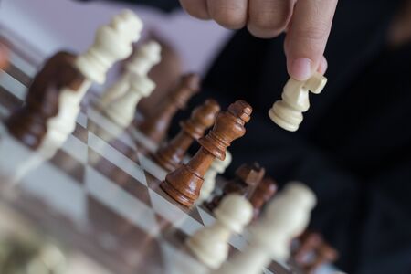 Close up shot hand of business woman playing the chess board to win by killing the king of opponent metaphor business competition winner and loser select focus shallow depth of fieldの写真素材