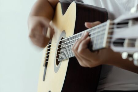 Woman hands playing acoustic classic guitar the musician of jazz and easy listening style select focus shallow depth of field and motion blur techniqueの写真素材