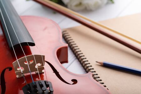 Close-up shot violin orchestra instrumental over white wooden background shallow depth of field select focusの写真素材