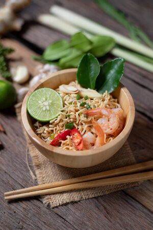 Close-up shot Instant noodles with lemon shrimp chilli hot and spicy on old wooden table select focus shallow depth of fieldの写真素材