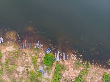 Drone shot aerial view scenic landscape the fishing boat in a big river with fresh green tree and beachの写真素材