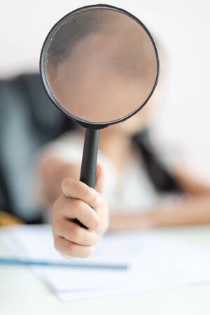 Little Asian girl using magnifier doing homework for education concept select focus shallow depth of fieldの写真素材