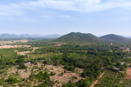 Drone shot aerial view scenic landscape of agriculture farm against mountain and nature forestの写真素材